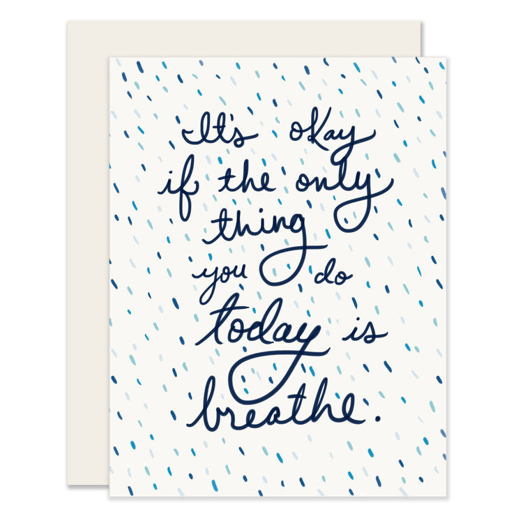 White card with blue text saying, “It’s okay if the only thing you do today is breathe.” Images of ombre blue dots scattered around card. A white envelope is included.