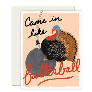 Peach card with black and red text saying, “Came In Like A Butterball”. Image of a large turkey riding on a gray wrecking ball attached to a chain. An white envelope is included.