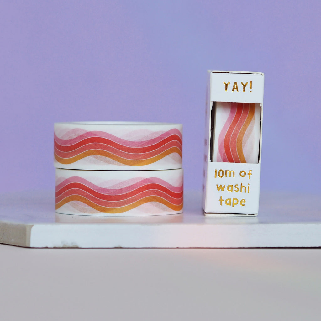 Decorative tape with white background with images of a red, pink and orange wavy rainbow.
