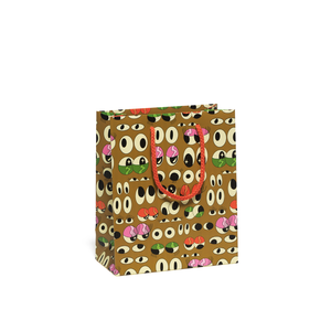 Image of gift bag with light brown background with images of eyes in black and ivory and pink and green eyelids with red cord handle. 