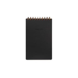Image of black cover with letter pressed text says, “Task pad”. “Name” and “Date” with lines for writing. Coiled binding on top.