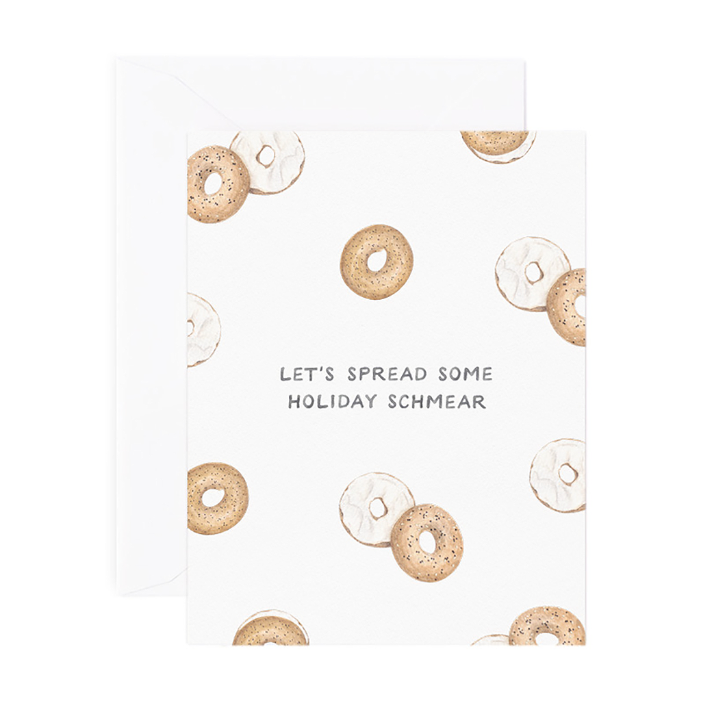 Ivory card with black text saying, “Let’s Spread Some Holiday Schmear”.  Images of bagels and cream cheese. An ivory envelope is included.