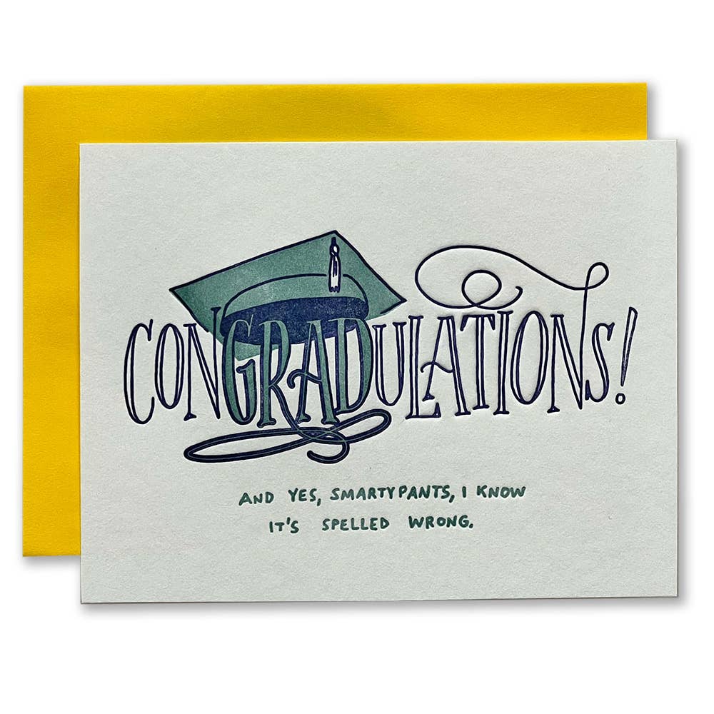 Ivory background with blue and green text says, “Congradulations! And Yes, smartypants, I know it's spelled wrong.” Image of graduation cap over the word GRADl. A yellow encelope is included.     