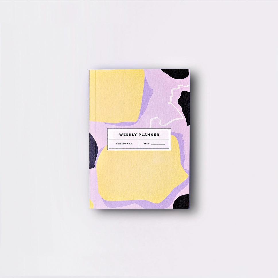 Image of planner cover with lavender background and yellow areas with black and white accents. Black outlined white  rectangle with black text says, "Weekly planner", Mulberry No. 1" and "Date" with line for writing. 