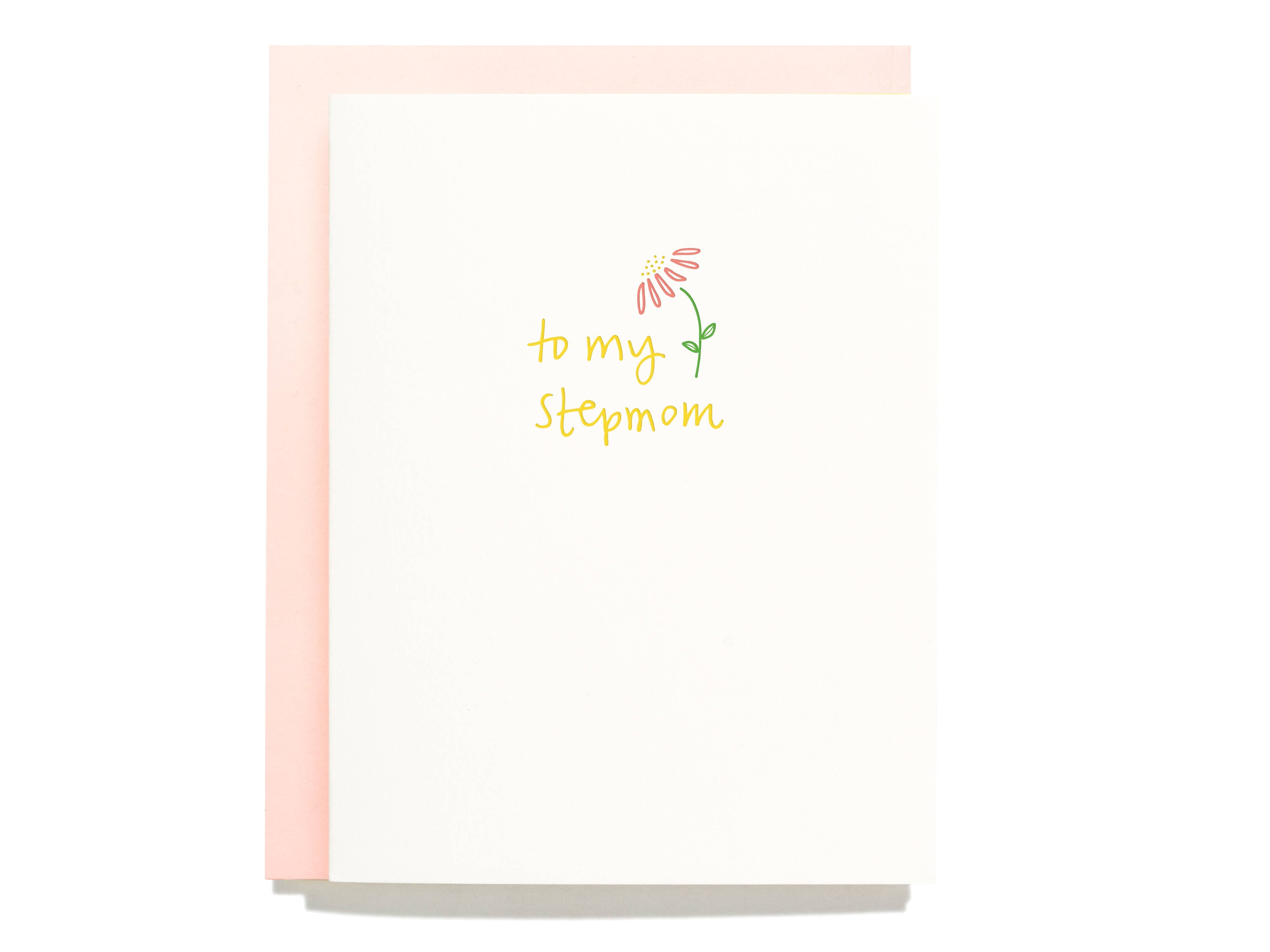 White card with yellow text saying, “To My Stepmom”. Images of a pink daisy with green stem on right side of text. A light pink envelope is included.