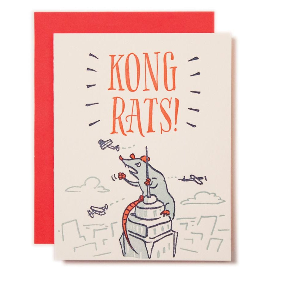 Ivory card with red text saying, "Kong Rats!"  Image of a giant rat climbing the top of the Empire State Building. Airplanes and clouds in background. A red envelope is included.