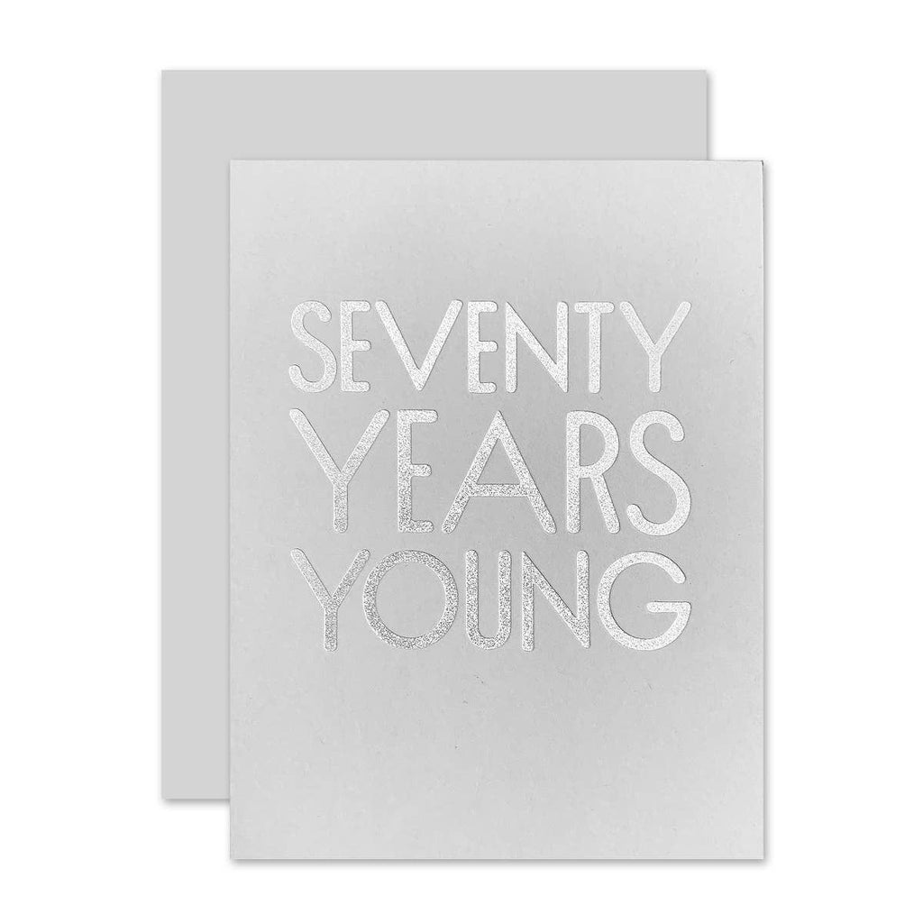 Gray card with silver foil text saying, “Seventy Years Young”. A gray envelope is included.