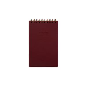 Image of burgundy cover with letter pressed text says, “Task pad”. “Name” and “Date” with lines for writing. Coiled binding on top.
