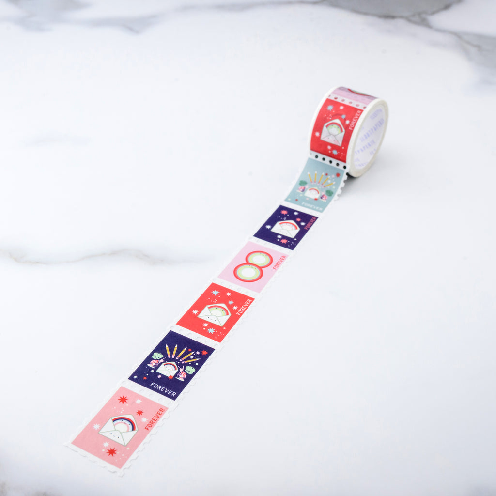 Decorative tape with pink, red, blue and green background colors with images of white mailing envelopes with smiley faces, pencils, snails, fireworks and rings all designed as individual forever stamps.