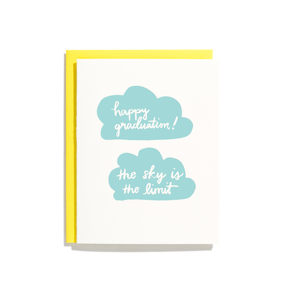 White card with images of two blue clouds with white text. One cloud says, “Happy Graduation!” The other cloud saying, “The Sky is the Limit”. A yellow envelope is included.