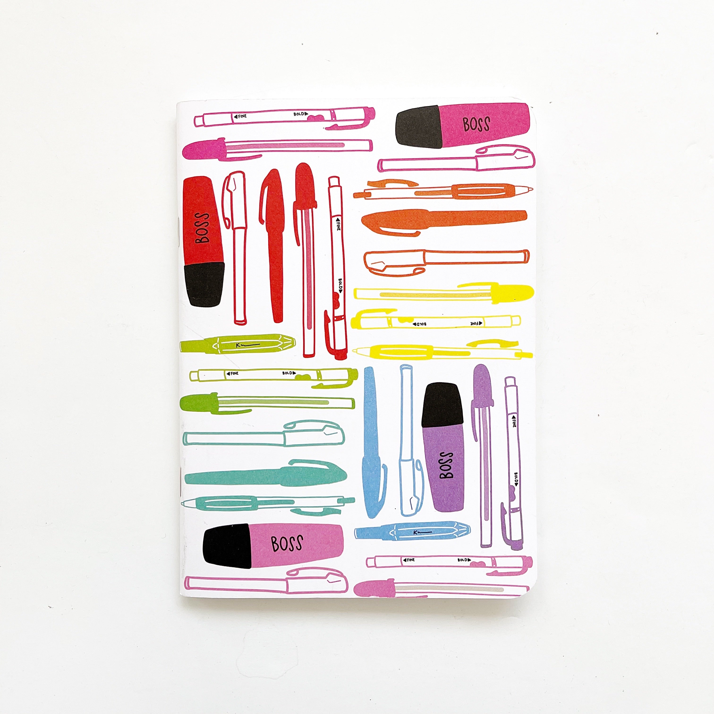Image of notebook with white background and images of colorful pens and markers in rainbow colors. 