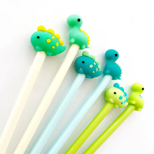 Image of six pens. A light green stegosaurus with yellow spots and scales on a yellow barrel, a light green brachiosaurus with yellow scales on a yellow barrel, a teal stegosaurus with light green dots and scales on a blue barrel, a teal brachiosaurus with light green scales on a blue barrel, a bright green stegosaurus with teal spots and scales on a bright green barrel and a bright green brachiosaurus with teal scales on a bright green barrel.      