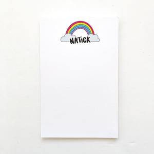 Notepad with white background and image at top of rainbow with clouds at both ends and black text says, "Natick". 